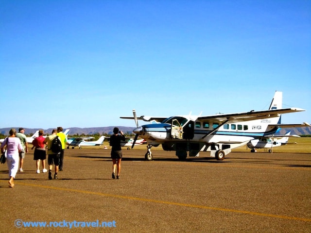 Group of people stepping towards a tiny plane.