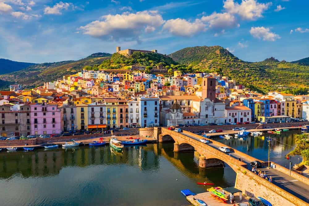 Aerial view of the beautiful village of Bosa with colored houses and a medieval castle. Bosa is located in the north-wesh of Sardinia, Italy. Aerial view of colorful houses in Bosa village, Sardegna. Colourful Bosa Sardinia